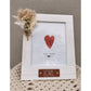 Photo frame with 'love' inscribed on leather look badge and includes a dried floral posy on top left corner of frame