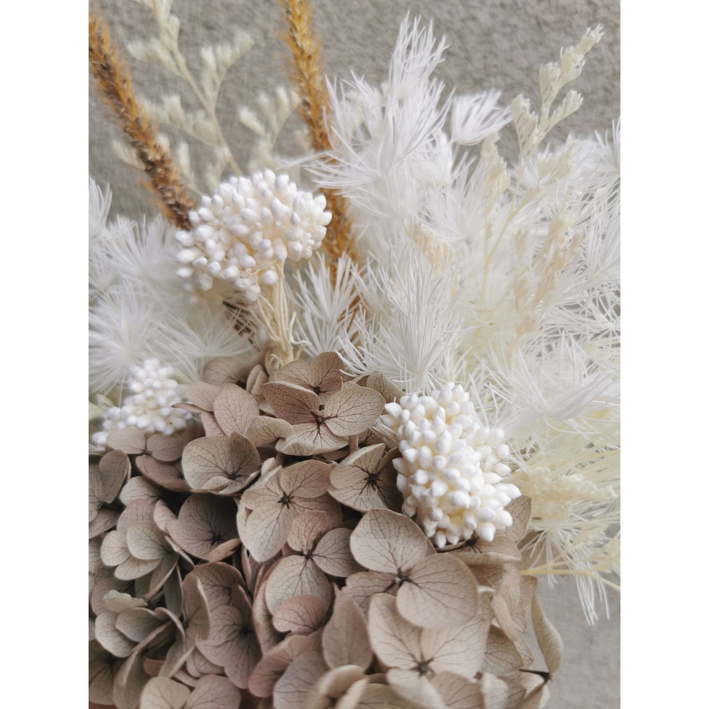 Neutral coloured dried & preserved flower arrangement. Photo shows a close up photo of the neutral coloured flowers