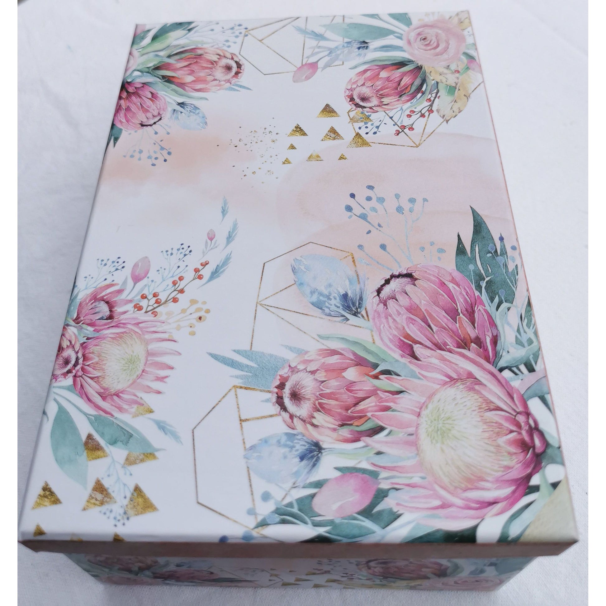 Photo shows a picture of the gift box on its own. The box design is floral with pink proteas